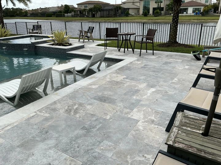 Restored concrete paver pool deck with seating area in Miramar